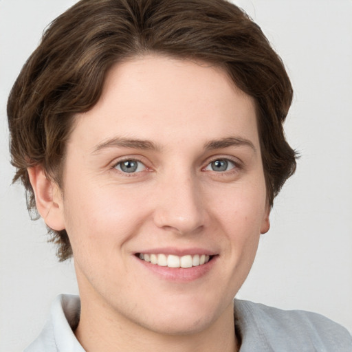 Joyful white young-adult female with short  brown hair and grey eyes