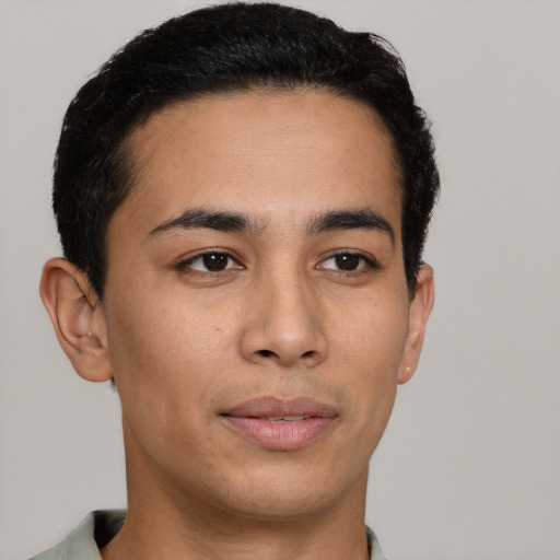 Joyful latino young-adult male with short  brown hair and brown eyes