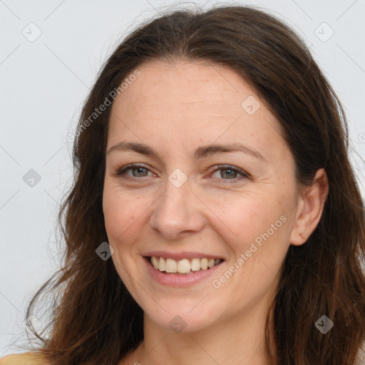 Joyful white adult female with long  brown hair and brown eyes