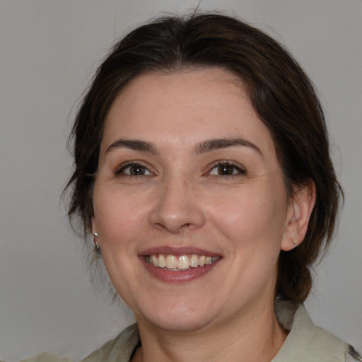 Joyful white adult female with medium  brown hair and brown eyes