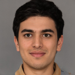 Joyful latino young-adult male with short  brown hair and brown eyes