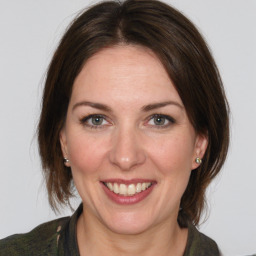 Joyful white adult female with medium  brown hair and grey eyes