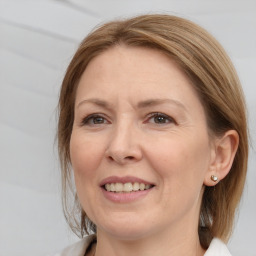 Joyful white adult female with medium  brown hair and brown eyes