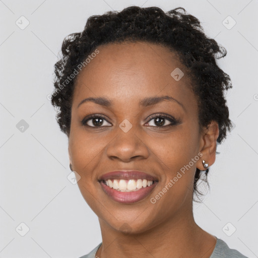 Joyful black young-adult female with short  brown hair and brown eyes