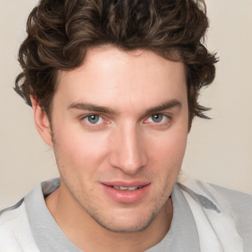 Joyful white young-adult male with short  brown hair and blue eyes