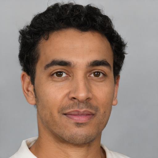Joyful latino young-adult male with short  brown hair and brown eyes