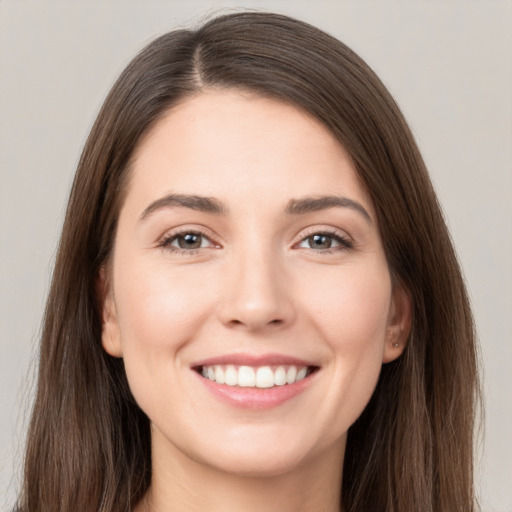 Joyful white young-adult female with long  brown hair and brown eyes