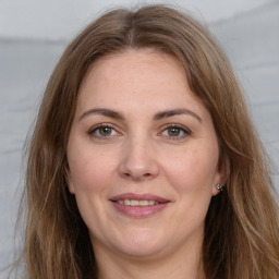 Joyful white adult female with long  brown hair and grey eyes