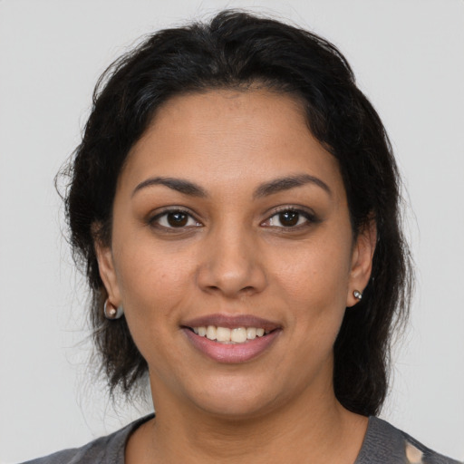 Joyful latino young-adult female with medium  brown hair and brown eyes