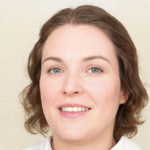 Joyful white young-adult female with medium  brown hair and blue eyes