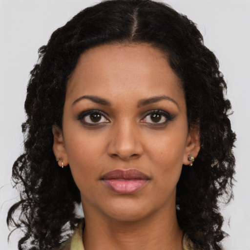 Joyful black young-adult female with long  black hair and brown eyes