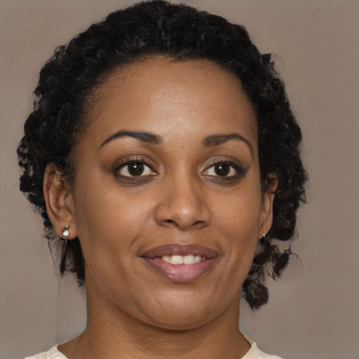 Joyful black adult female with medium  brown hair and brown eyes