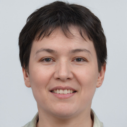 Joyful white young-adult female with short  brown hair and grey eyes