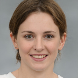 Joyful white young-adult female with medium  brown hair and green eyes