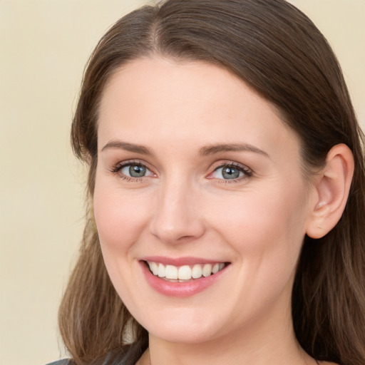 Joyful white young-adult female with long  brown hair and grey eyes