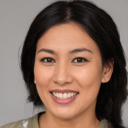 Joyful asian young-adult female with long  brown hair and brown eyes