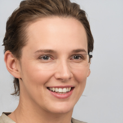 Joyful white young-adult female with medium  brown hair and grey eyes