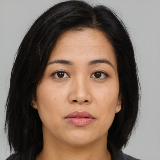 Joyful asian young-adult female with long  brown hair and brown eyes