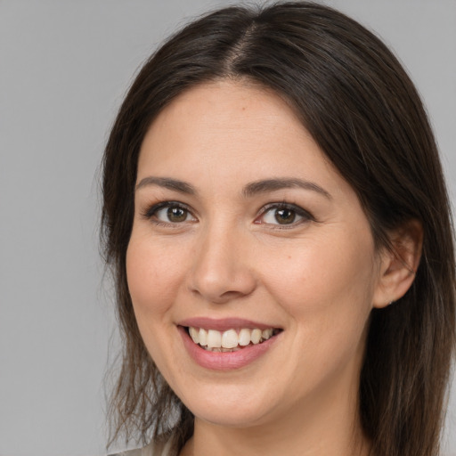 Joyful white young-adult female with long  brown hair and brown eyes