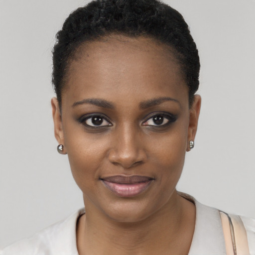 Joyful black young-adult female with short  black hair and brown eyes