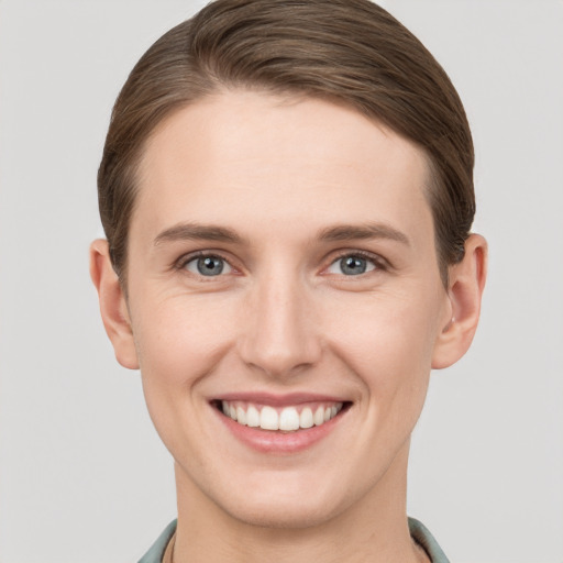 Joyful white young-adult female with short  brown hair and grey eyes