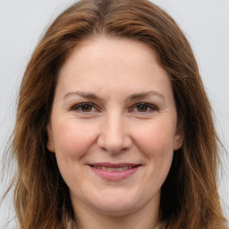 Joyful white adult female with long  brown hair and brown eyes