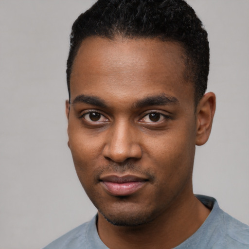 Joyful black young-adult male with short  black hair and brown eyes