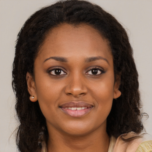 Joyful black young-adult female with long  brown hair and brown eyes