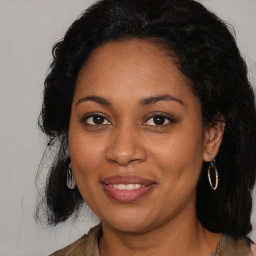 Joyful black young-adult female with long  black hair and brown eyes