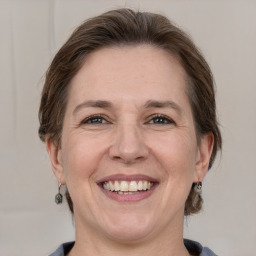 Joyful white adult female with medium  brown hair and grey eyes