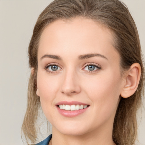 Joyful white young-adult female with long  brown hair and blue eyes