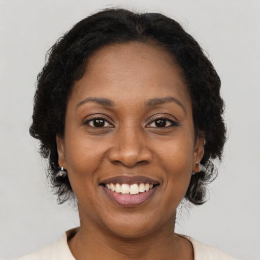 Joyful black adult female with medium  brown hair and brown eyes