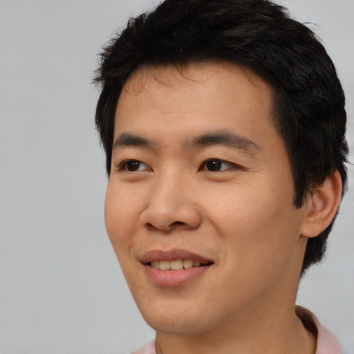 Joyful asian young-adult male with short  black hair and brown eyes
