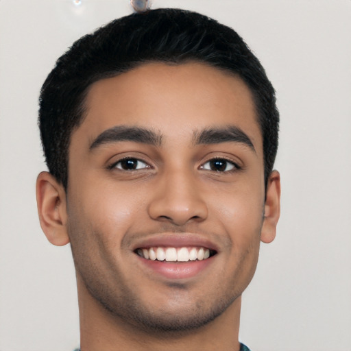 Joyful latino young-adult male with short  black hair and brown eyes