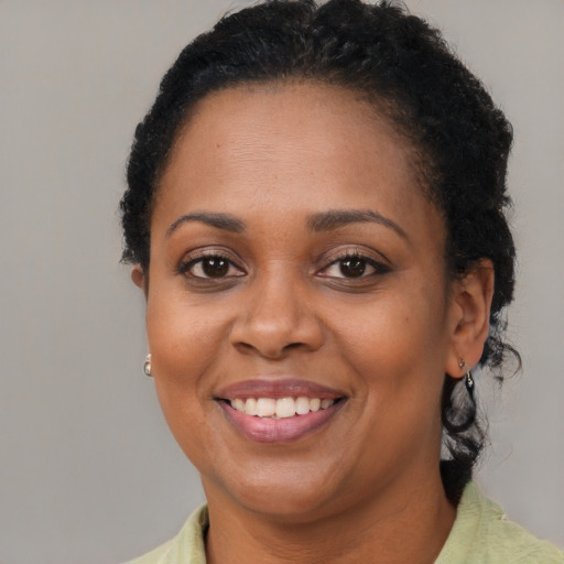 Joyful black adult female with short  brown hair and brown eyes