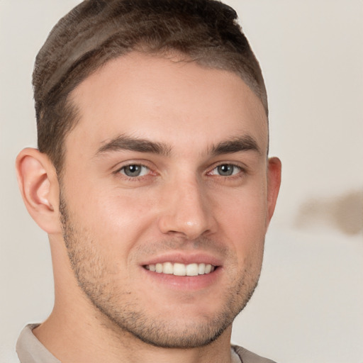 Joyful white young-adult male with short  brown hair and brown eyes