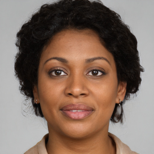 Joyful black young-adult female with medium  brown hair and brown eyes