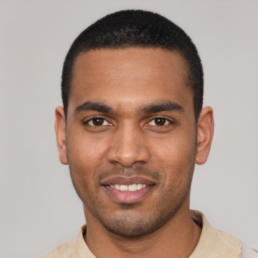 Joyful black young-adult male with short  black hair and brown eyes