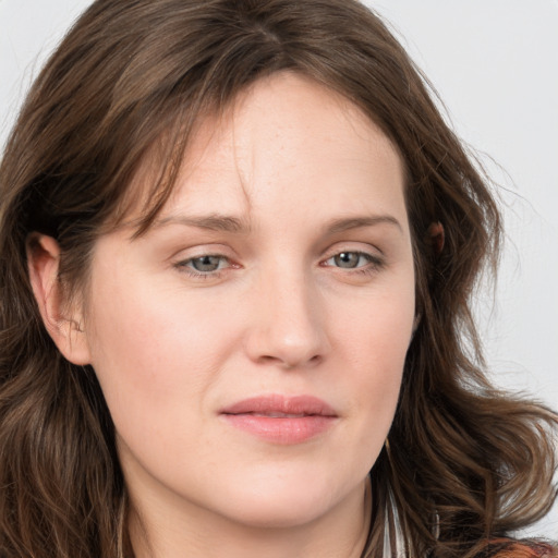 Joyful white young-adult female with long  brown hair and blue eyes