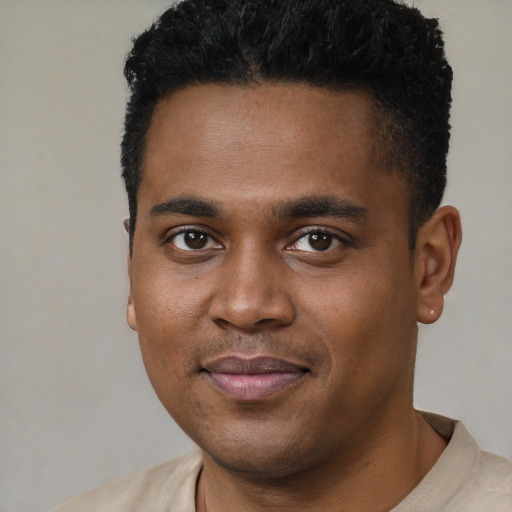 Joyful black young-adult male with short  black hair and brown eyes