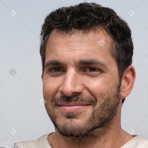 Joyful white adult male with short  black hair and brown eyes