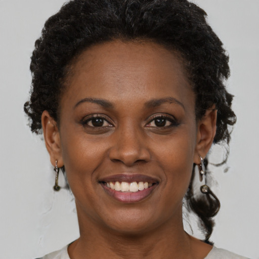 Joyful black young-adult female with short  brown hair and brown eyes