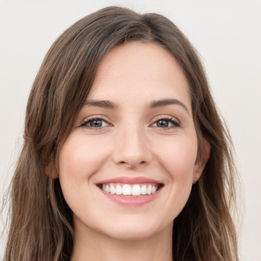 Joyful white young-adult female with long  brown hair and green eyes