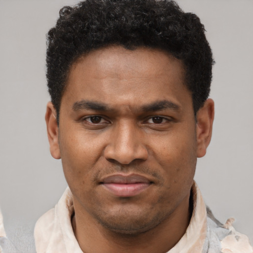 Joyful latino young-adult male with short  brown hair and brown eyes