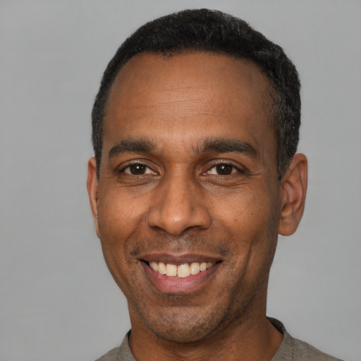 Joyful latino adult male with short  black hair and brown eyes