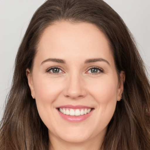 Joyful white young-adult female with long  brown hair and brown eyes