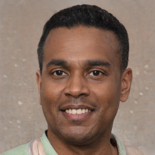 Joyful black young-adult male with short  black hair and brown eyes