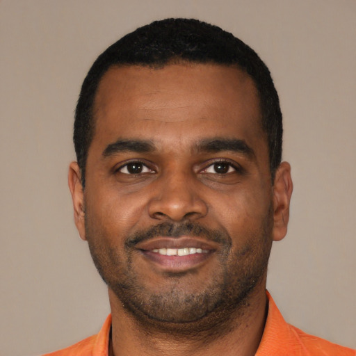 Joyful black young-adult male with short  black hair and brown eyes