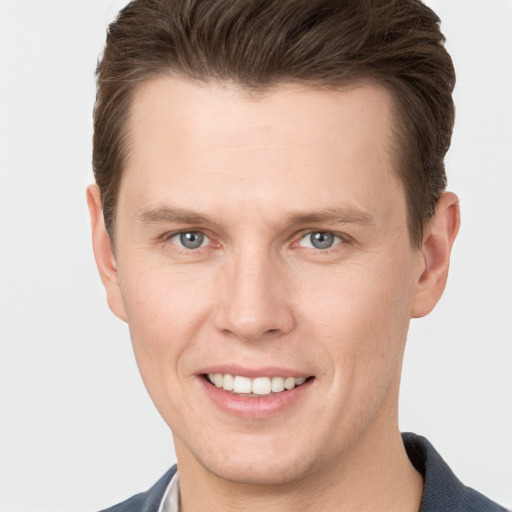 Joyful white young-adult male with short  brown hair and grey eyes