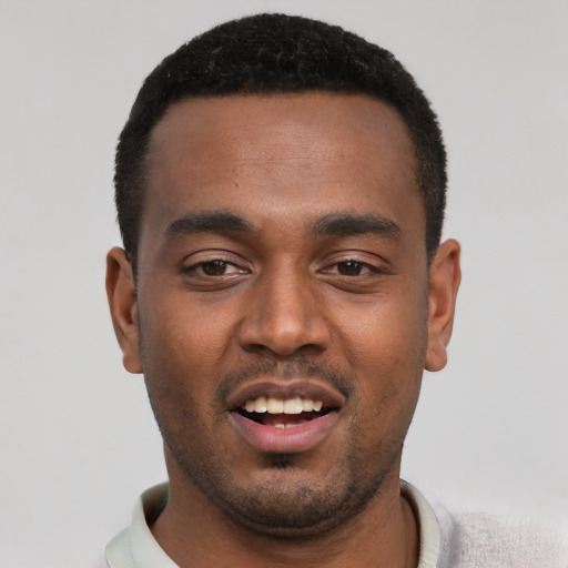 Joyful black young-adult male with short  black hair and brown eyes